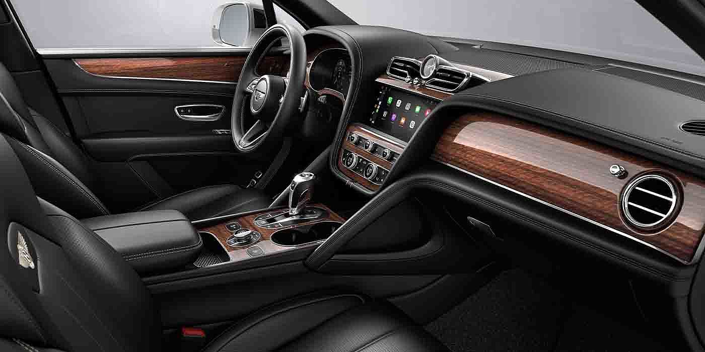Bach Premium Cars GmbH Bentley Bentayga EWB interior with a Crown Cut Walnut veneer, view from the passenger seat over looking the driver's seat.