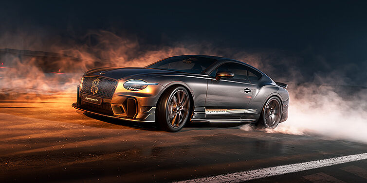 Bach Premium Cars GmbH Bentley Supersports front three quarter in "Nightfall" Design theme with Anthracite paint, Camel accents and Camel and Beluga black striping standing on mist covered concrete
